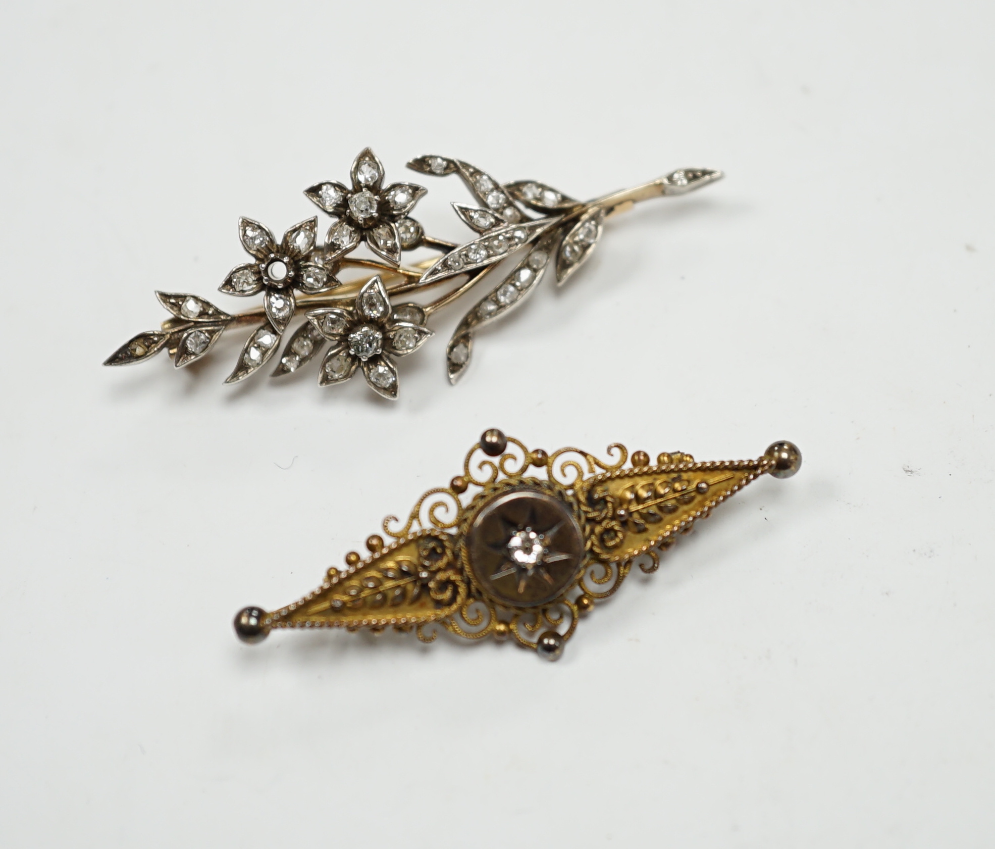 A late Victorian, yellow metal, white metal and diamond cluster set foliate spray brooch, 53mm, together with a Victorian 15ct gold and singe stone diamond set bar brooch, gross weight 11.5 grams.